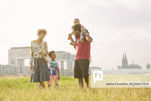 Germany  Cologne  family of four walking in a field