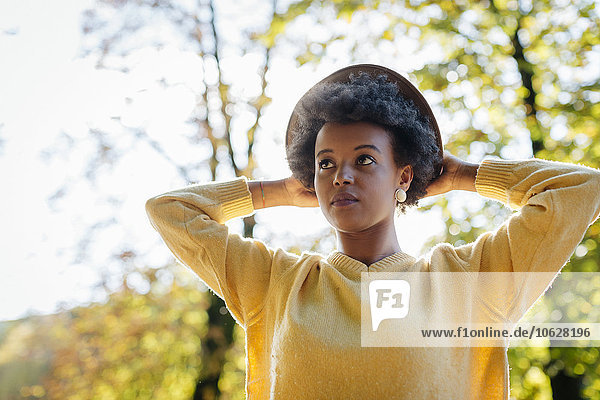 Schöne schwarze Frau mit Hut im Herbst im Freien