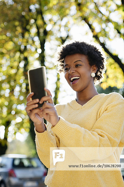 Schöne schwarze Frau mit Smartphone  Outdoor im Herbst