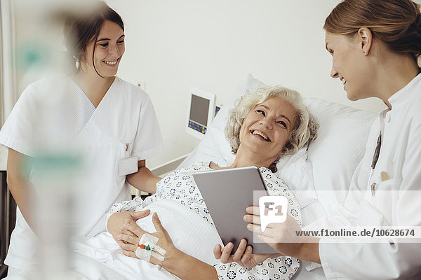 Senior woman in hospital talking to doctor and nurse
