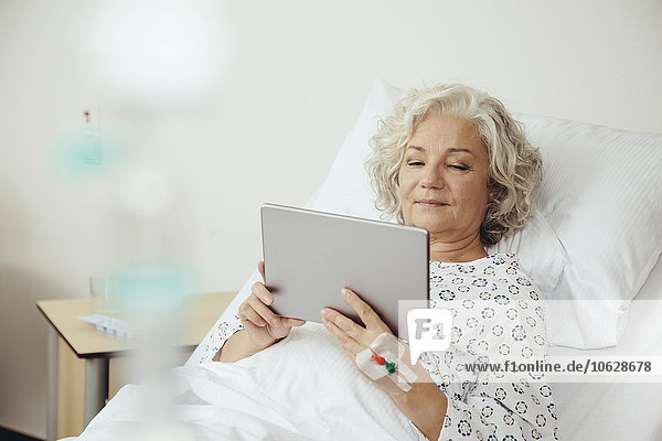 Seniorin im Krankenhaus mit digitalem Tablett