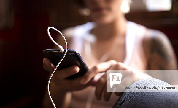 Young woman listening music with earphones  close-up