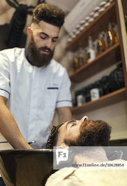 Friseur beim Haarewaschen eines Kunden
