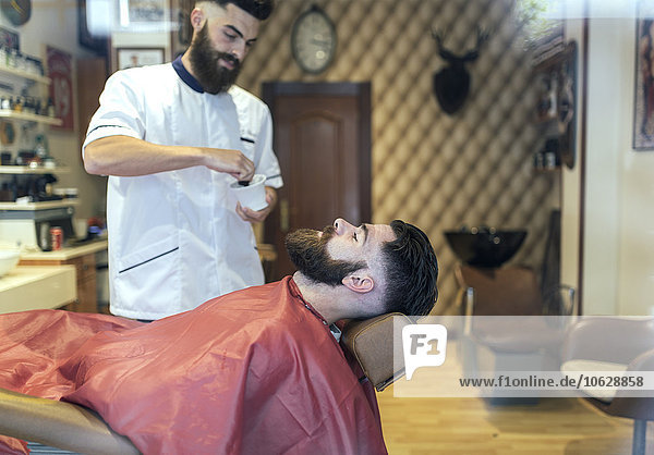 Barbier bei der Vorbereitung der Rasur für einen Kunden