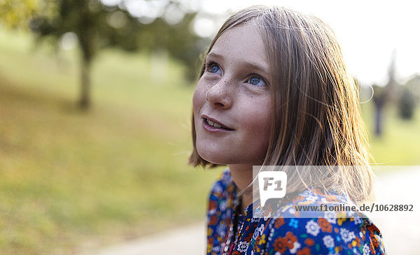 Porträt eines lächelnden  blonden Mädchens mit Sommersprossen