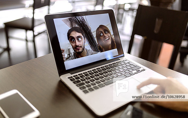Lustige Fotografie des jungen Paares auf dem Display des Laptops