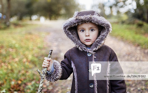 Portrait of little girl wearing hooded jacket in autumn
