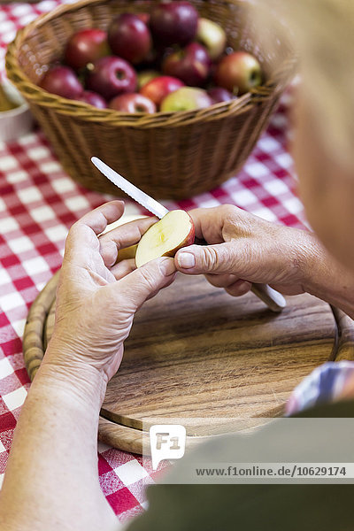 Seniorin beim Äpfelschneiden  Nahaufnahme