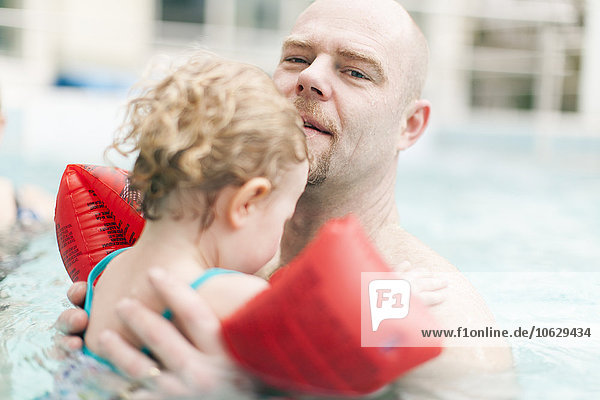 Vater mit kleiner Tochter im Schwimmbad