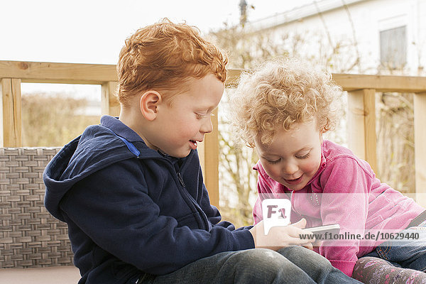 Little boy and girl looking at cell phone