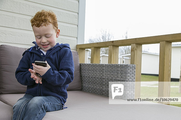 Smiling little boy looking at cell phone