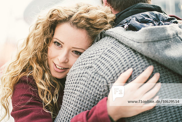 Portrait of smiling young woman hugging her boyfriend