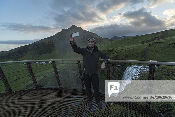 Iceland  Man taking selfie at Skogafoss waterfall