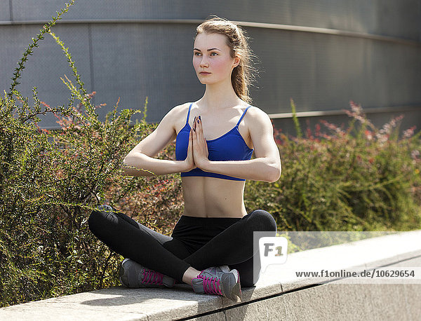 Young woman practicing yoga in the city