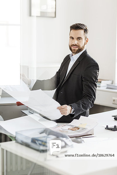 Man in office holding construction plan