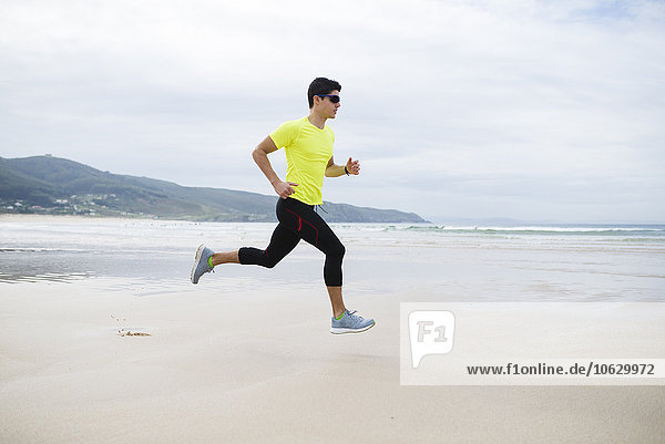 Spain  Ferrol  young man jogging on the beach