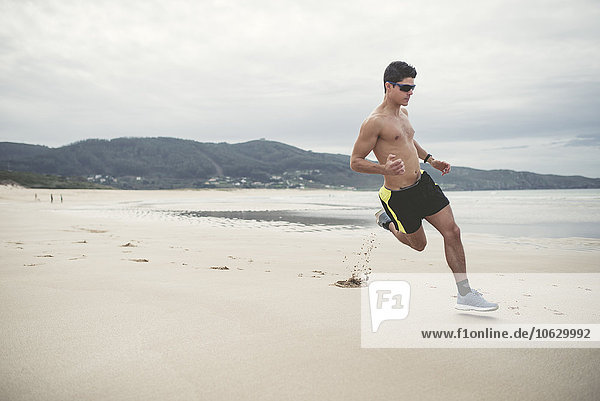Spain  Ferrol  young man running fast on the beach