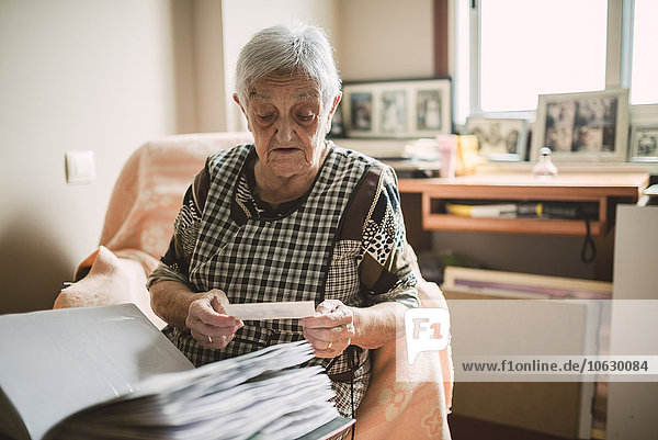 Senior woman looking at old photos of her childhood
