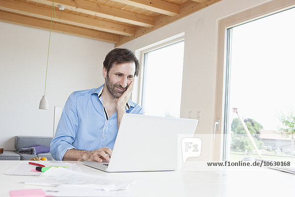 Mature man working from home  using laptop