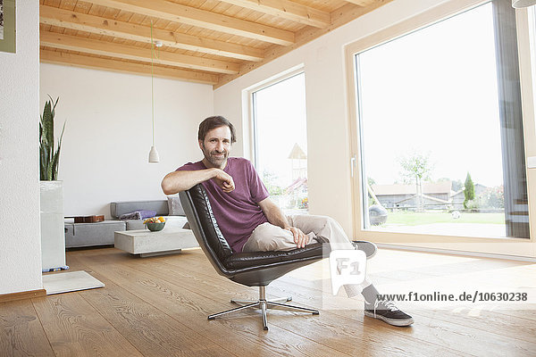 Mature man sitting relaxed in his living room