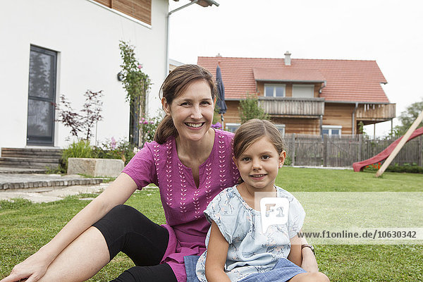 Portrait of smiling mother and daughter in garden