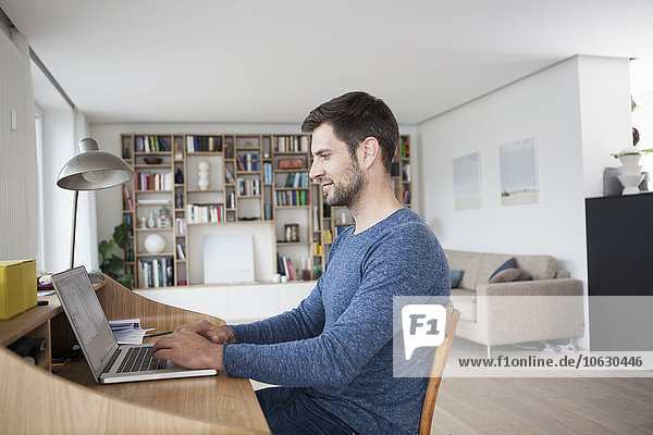 Man at home using laptop