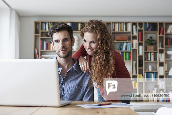 Couple at home looking at laptop