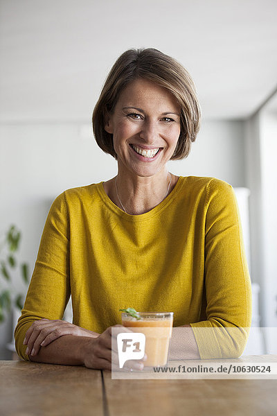 Porträt einer lächelnden Frau mit einem Smoothie