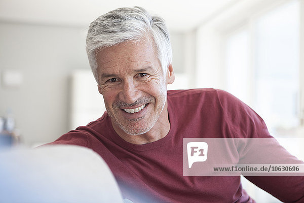 Porträt eines lächelnden reifen Mannes mit grauen Haaren und Stoppeln