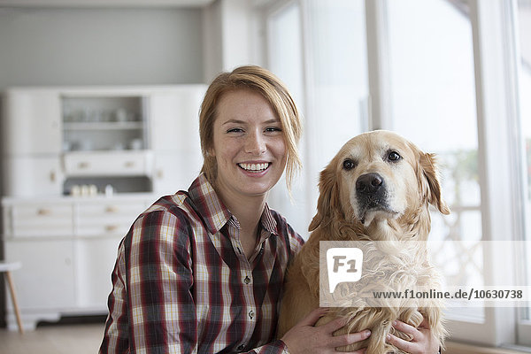 Porträt einer lächelnden jungen Frau mit ihrem Hund