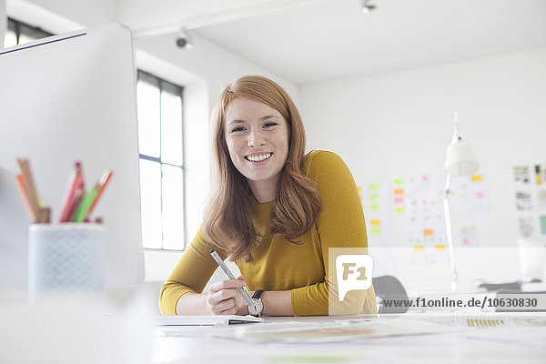Junge Frau im Büro arbeitet am Schreibtisch
