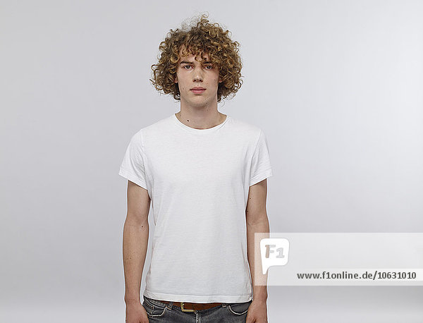 Portrait of young man with curly blond hair wearing white t-shirt