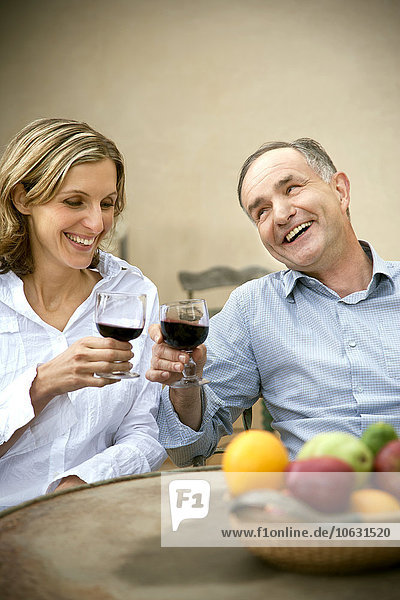 Two friends toasting with red wine