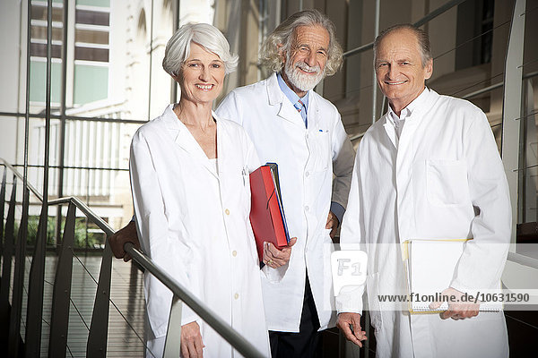 Three senior wearing laboratory coats at university