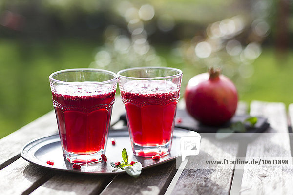 Granatapfelsirup mit Granatapfelsamen, Prosecco und Mineralwasser im Glas