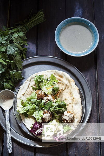 Hausgemachte Falafel mit Salat  Tahinisauce auf Fladenbrot