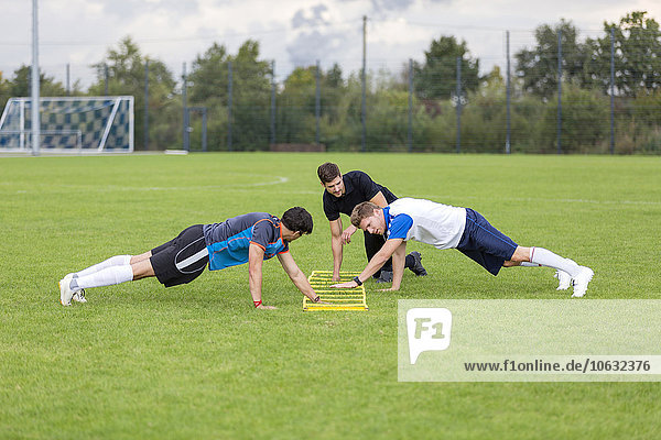 Trainer-Training mit Fußballspielern auf dem Sportplatz