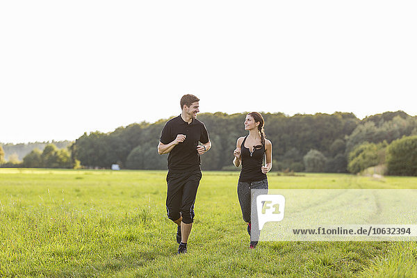 Man and woman jogging in field