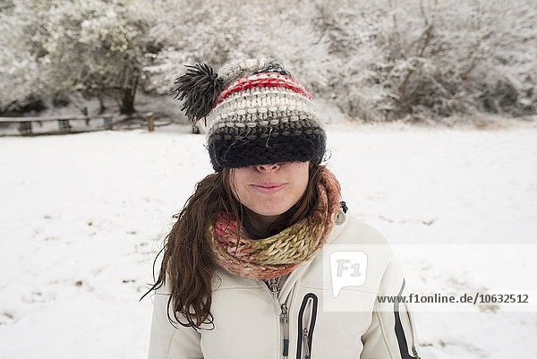 Junge Frau im Winter mit Wollmütze über den Augen