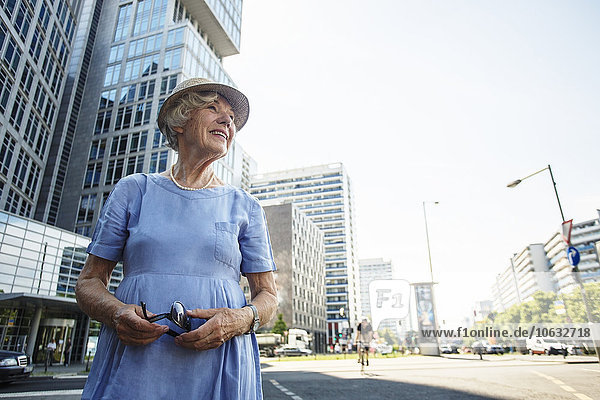 Deutschland  Berlin  Porträt einer lächelnden Seniorin  die sich etwas ansieht