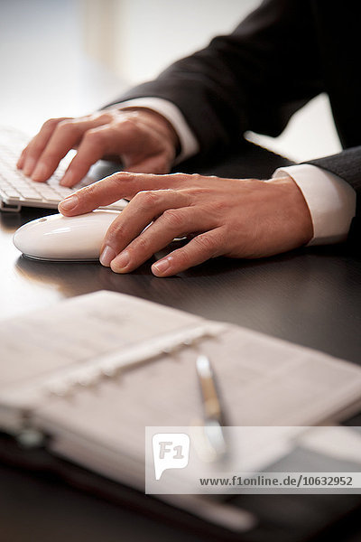 Hands of businessman using mouse and keyboard