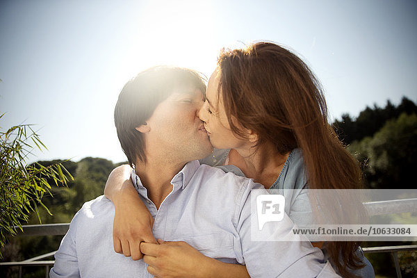 Couple kissing under blue sky