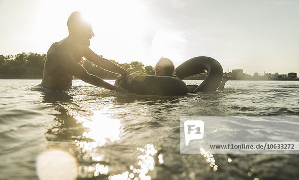 Happy couple with inner tube in water