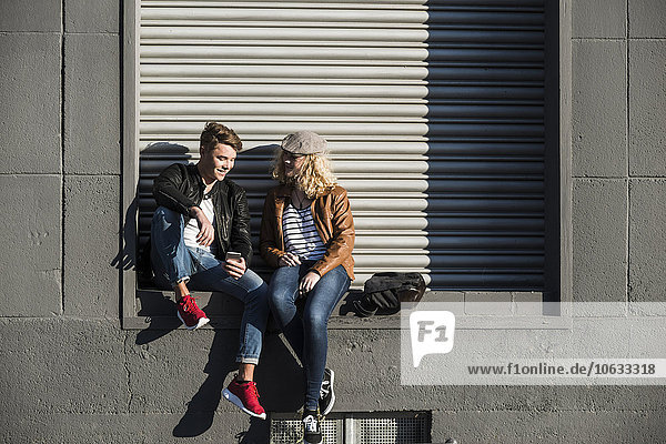 Entspanntes junges Paar mit Handy im Freien