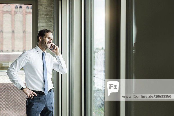 Portrait of businessman telephoning smartphone