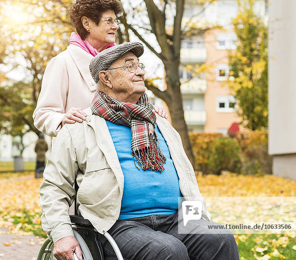 Seniorin mit Ehemann im Rollstuhl im Freien