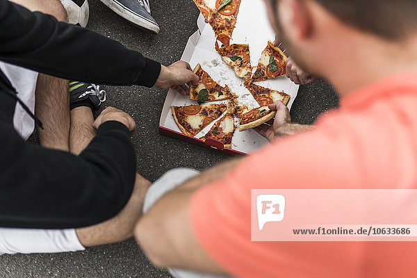 Young men eating pizza