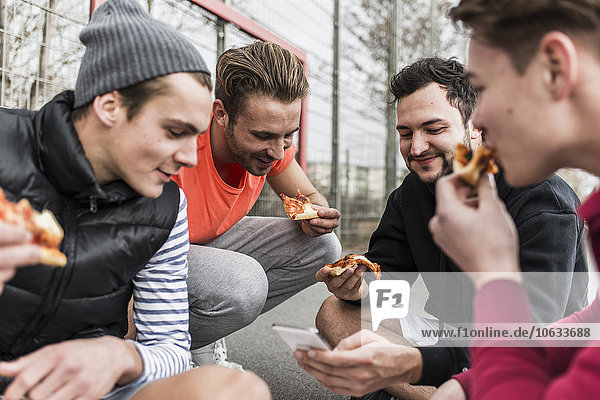 Young men eating pizza