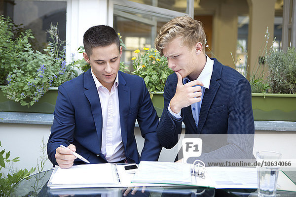 Two businessmen discussing paper