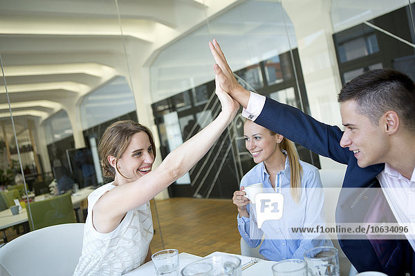 Happy businessman and businesswoman high fiving